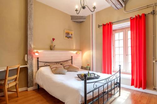 ein Schlafzimmer mit einem großen Bett mit roten Vorhängen in der Unterkunft Domaine Le Prieuré in Chaumont-le-Bourg