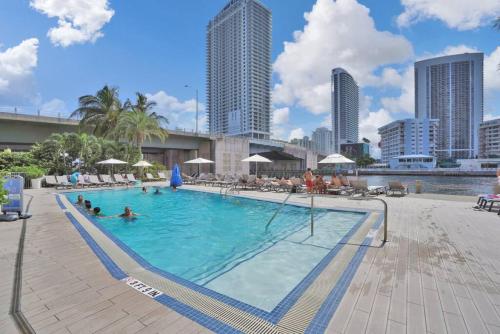 a large swimming pool with people in the water at Spacious Luxury Ocean View 4 Bdrs 3Baths 17 FL in Hallandale Beach