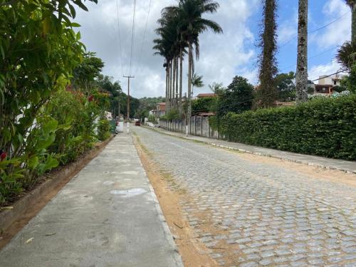 an empty street with palm trees on the side of the road at Aluguel Apto. Triplex Guaramiranga. in Guaramiranga