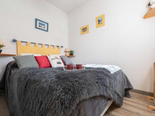 une chambre avec un lit avec une couverture grise dans l'établissement Appartement Confortable pour 4 à Saint-Lary Village, Proche Thermes et Télécabine - FR-1-296-356, à Saint-Lary-Soulan