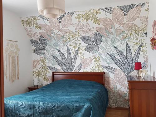 une chambre avec un lit avec un papier peint fleuri dans l'établissement Maison avec Jardin, Véranda, WIFI, à 2 km du Port de Perros-Guirec, St Quay-Perros - FR-1-368-313, à Saint-Quay-Perros