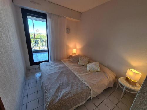 une petite chambre avec un lit et une fenêtre dans l'établissement Agréable 3 pièces avec 3 loggias, parking privé - Argelès-sur-Mer - FR-1-388-198, à Argelès-sur-Mer