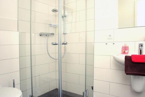 een badkamer met een douche, een toilet en een wastafel bij "Windrose" in der Villa am Marienhof in Borkum