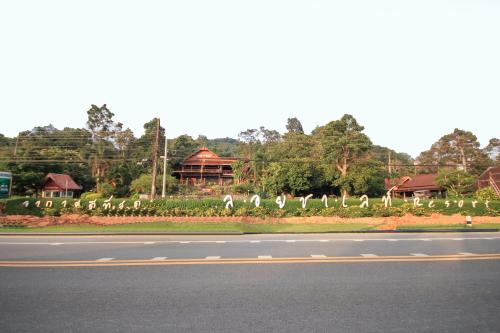 a group of white birds standing on the side of a road at OYO 75353 Loy Chalet Resort in Lan Saka