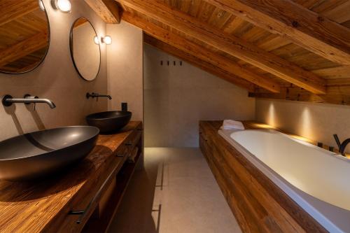 ein Badezimmer mit zwei Waschbecken und einer großen Badewanne in der Unterkunft Chalet Enigma in La Clusaz