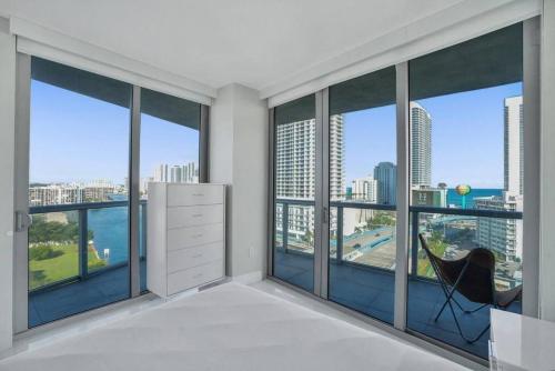 a room with large windows with a chair in front of it at Gorgeous 4 Bedroom Condo Pool and Stunning Views in Hallandale Beach