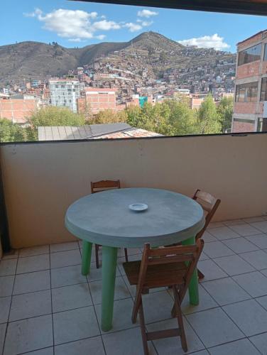 a table and chairs on a balcony with a view at Posada de Mama in Cusco
