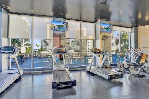 un gimnasio con máquinas cardiovasculares y vistas a la ciudad en Upscale Resort 4 Bedrooms 3 bath en Hallandale Beach