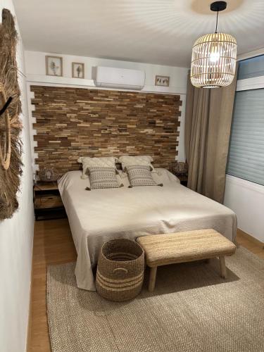 a bedroom with a large bed and a brick wall at AGUILA DORADA in Salou