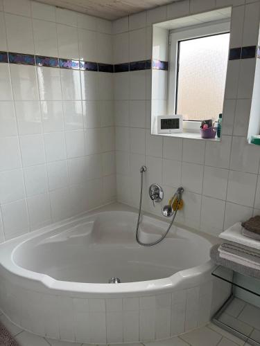 a white tub in a bathroom with a window at Superschöne Ferienwohnungen! in Buxheim