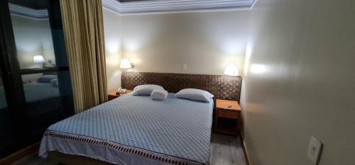 a bedroom with a bed with two pillows on it at Cobertura Alto luxo Tropical hotel in Manaus