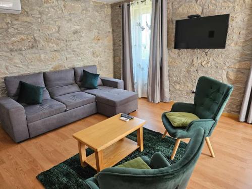 a living room with a couch and two chairs and a table at Casasoutelo in Carrazedo