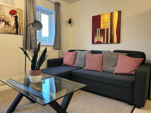 a living room with a couch and a glass table at Lovely Serviced Apartment, Free Parking, Oxford in Oxford