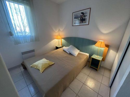 - une petite chambre avec un lit et deux lampes dans l'établissement Port Camargue: appt 2 pièces 5 pers, parking, terrasse - FR-1-250-199, au Grau-du-Roi