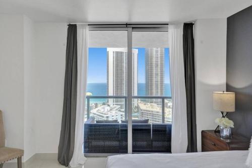 a bedroom with a window with a view of the ocean at Stunning Beach Resort Large 4 Bedrooms Apartment in Hallandale Beach