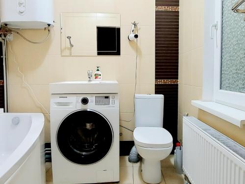 uma casa de banho com uma máquina de lavar roupa e um WC em 2 комнатная 3-я Слободская и Кузнецкая em Nikolayev