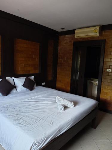 a bedroom with a large bed with white sheets at Wilai Villa Lamai in Lamai