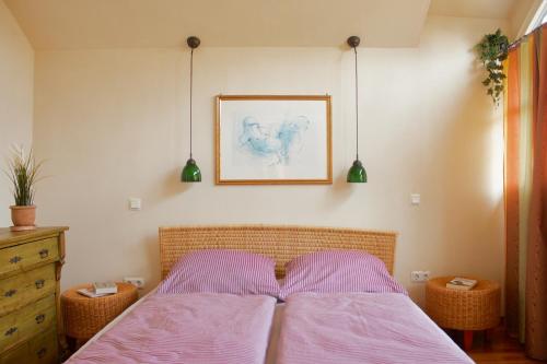 a bedroom with a bed with pink sheets and a picture at Ferienwohnung am Dorfbrunnen 