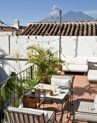 a patio with chairs and tables on a roof at Cacao Boutique Hotel in Antigua Guatemala