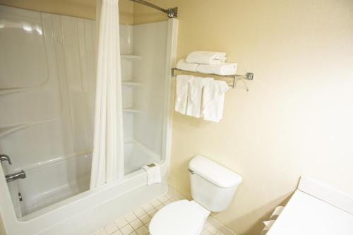 a bathroom with a shower and a toilet and towels at Country Inn & Suites by Radisson, Harrisburg West Mechanicsburg in Mechanicsburg