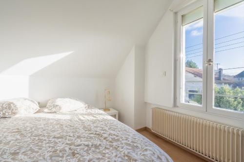 a white bedroom with a bed and a window at Paris JO 2024 L élégante in Soisy-sous-Montmorency