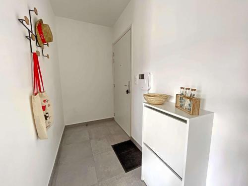 - une cuisine blanche avec un réfrigérateur et une porte dans l'établissement Studio moderne 30m² avec balcon et parking, accès direct plage et commerces, entièrement équipé. - FR-1-646-11, à Berck-sur-Mer