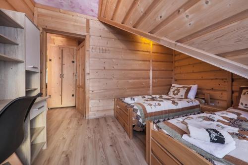 グリツァルフにあるApartament i pokoje Grota Zbójnickaのログキャビン内のベッドルーム1室(ベッド2台付)