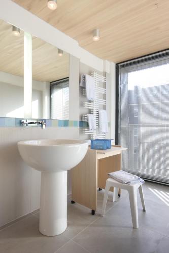 a bathroom with a sink and a desk and a chair at Hotel Niedersachsen in Westerland (Sylt)