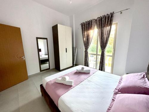 a bedroom with a bed with two towels on it at Shell Home golem 1 in Golem