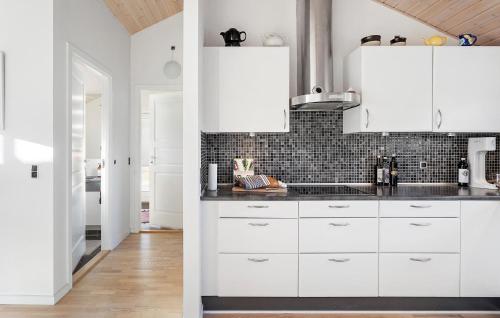 two views of a kitchen with white cabinets at 3 Bedroom Gorgeous Home In Dannemare in Dannemare