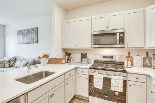 uma cozinha com armários brancos e um forno com placa de fogão em Air Home , New Jersey, year 2023 em Sicklerville