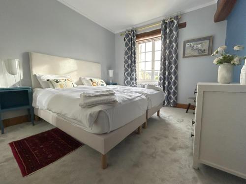 a bedroom with a large white bed with a window at Domaine Chapelle in La Chapelle-la-Reine
