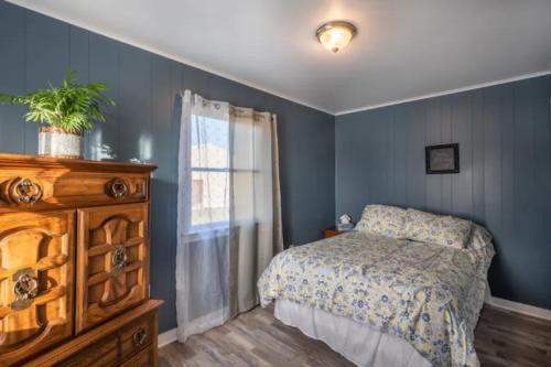 ein Schlafzimmer mit einem Bett, einer Kommode und einem Fenster in der Unterkunft Oakbend Cottage in Newville