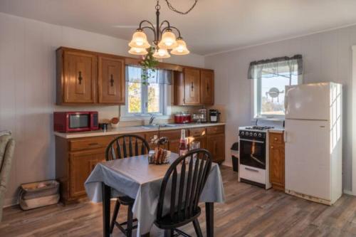 eine Küche mit einem Tisch und einem weißen Kühlschrank in der Unterkunft Oakbend Cottage in Newville