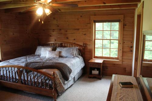 ein Schlafzimmer mit einem Bett in einem Blockhaus in der Unterkunft Robin Hill in Georgetown