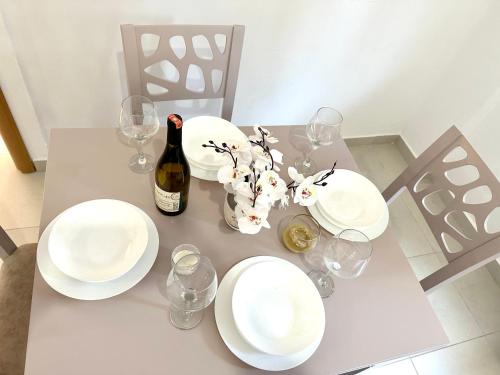 a table with white plates and a bottle of wine at Shell Home golem 1 in Golem