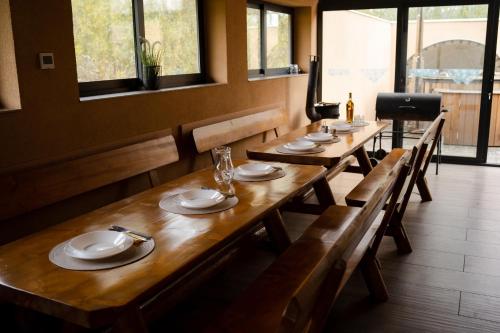 una fila de mesas de madera en un restaurante en U divokej včely, en Ižipovce