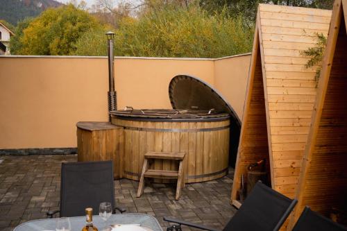 a hot tub and a barrel with a table and chairs at U divokej včely in Ižipovce