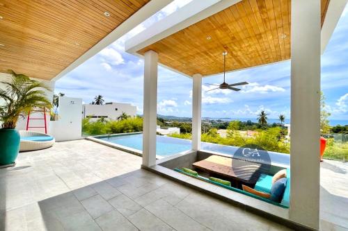 un patio al aire libre con piscina y techo en Villa Gratia Alba en Nathon Bay