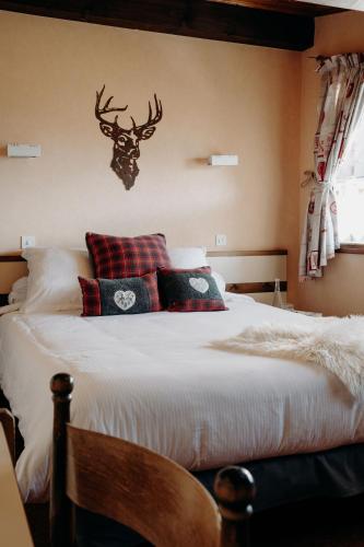 - une chambre avec un lit avec une tête de cerf sur le mur dans l'établissement Hôtel Le Christania, à Bellevaux