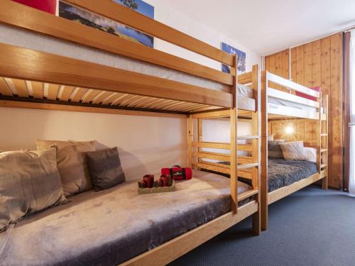 - une chambre avec 2 lits superposés et des chaussures au sol dans l'établissement Appartement 6 pers. proche pistes avec cheminée - FR-1-296-385, à Saint-Lary-Soulan