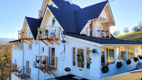 a white house with a black roof at Carpathia Magic -adults only in Peştera