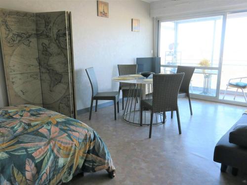 une chambre avec un lit, une table et des chaises dans l'établissement Appartement au port avec loggia et vue mer - Perros-Guirec - FR-1-368-336, à Perros-Guirec