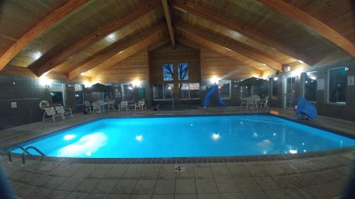 a large swimming pool in a building with a wooden ceiling at GrandStay Hotel & Suites in Cambridge