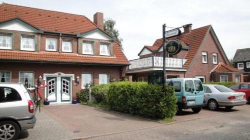 a group of cars parked in front of a house at Hotel Pension Friesenruh in Bensersiel
