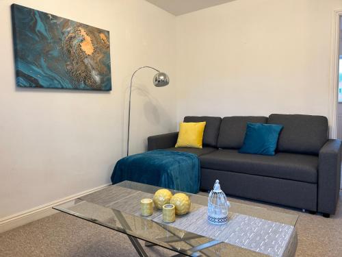 a living room with a couch and a glass table at Elegant Serviced Apartment with Parking in Oxford in Oxford
