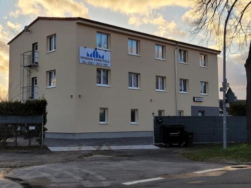 - un grand bâtiment blanc avec un panneau dans l'établissement Pension Forstfeld Kassel, à Cassel