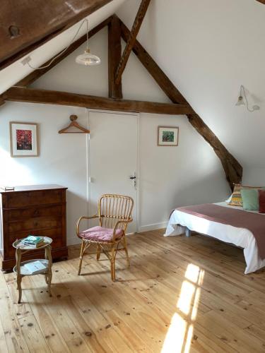 a bedroom with a bed and a chair and a table at La Grimaudière in La Chapelle-sur-Erdre
