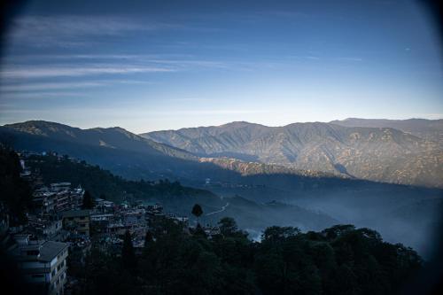 een uitzicht op een vallei met bergen in de verte bij Family Homestay Darjeeling in Darjeeling