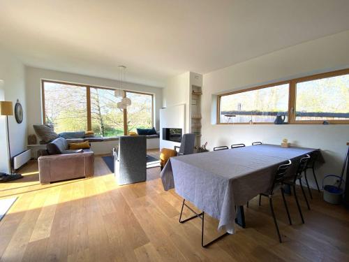 un grand salon avec une table et des chaises dans l'établissement Villa neuve en bois avec WIFI et jardin, à proximité de la plage de Trestraou, Perros-Guirec - FR-1-368-353, à Perros-Guirec